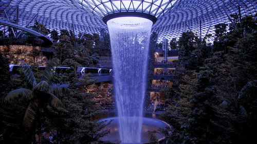 Fountain by trees against sky