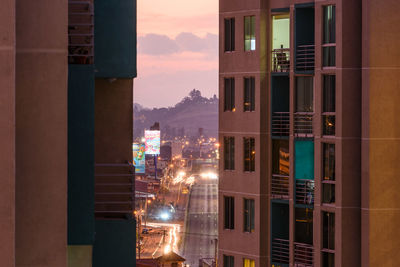 Illuminated buildings against sky at sunset