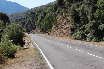 Road by mountains with trees