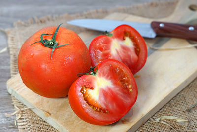 High angle view of tomatoes over cutting board on table