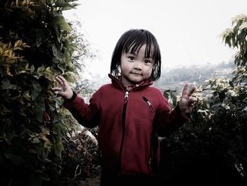 Portrait of cute girl standing against plants