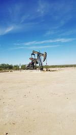 Oil drill on field against sky