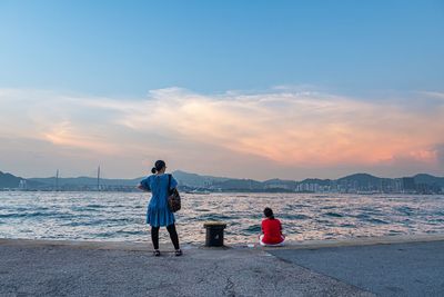 Rear view of woman looking at sea against sky