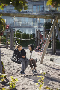 Friends sitting on swing