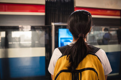 Rear view of woman standing against blurred background