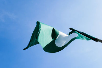 Low angle view of flags against clear blue sky