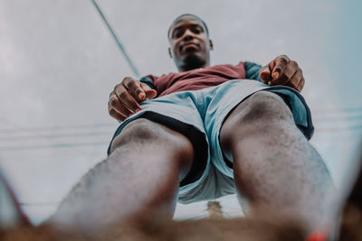 Low angle view of young man looking at camera