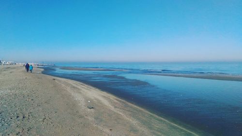 Scenic view of beach against clear blue sky