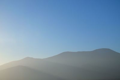 Scenic view of mountains against clear blue sky