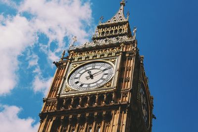 Low angle view of clock tower against cloudy sky