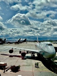 Airplane on airport runway against sky