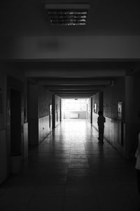 Rear view of silhouette man walking in corridor of building