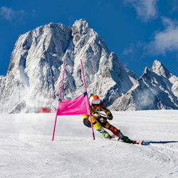 Person skiing on snowcapped mountain against sky