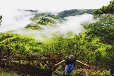 High angle view of woman standing against mountains during foggy weather