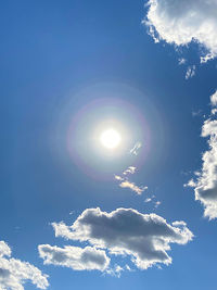 Low angle view of sun shining in blue sky