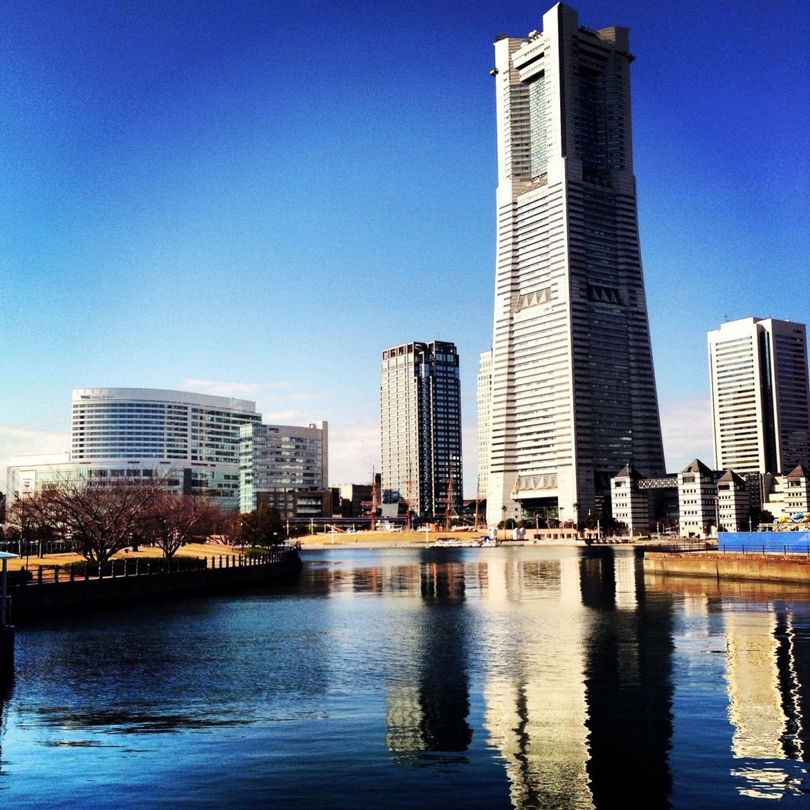 building exterior, architecture, city, skyscraper, built structure, water, tall - high, office building, modern, urban skyline, waterfront, cityscape, tower, clear sky, financial district, blue, river, reflection, skyline, building