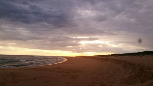 Scenic view of beach against sky during sunset