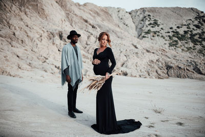 Full length of couple standing on sand in desert