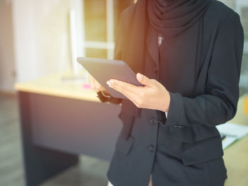 Midsection of man using mobile phone