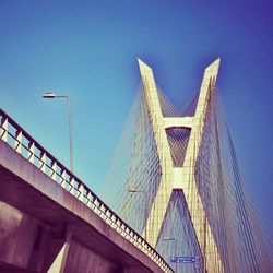 Low angle view of bridge against clear blue sky