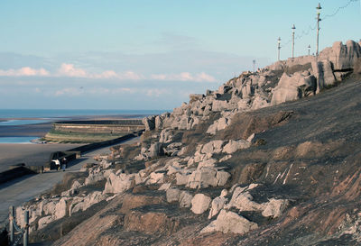 Scenic view of rocks on beach against sky