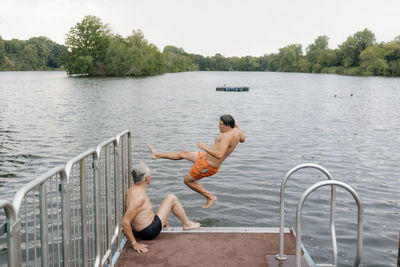 Man jumping from jetty into a lake