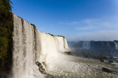 Scenic view of waterfall against sky