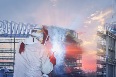 Man working in city against sky