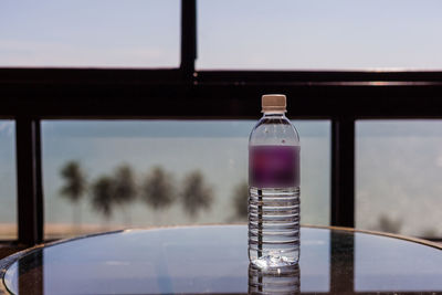 Close-up of water bottle on glass window