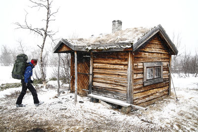 Backpacker near wooden house