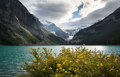 Scenic view of lake by mountains against sky