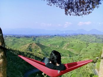 Man relaxing in hammock over landscape