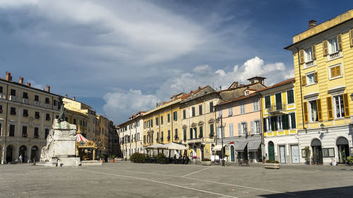 Street by buildings in town against sky