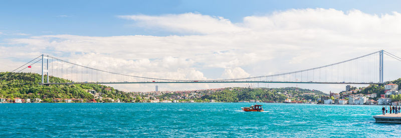 Bosphorus bridge over strait against sky