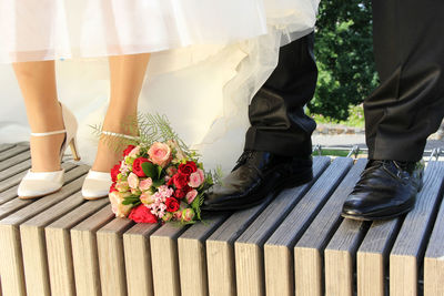 Low section of wedding couple standing outdoors