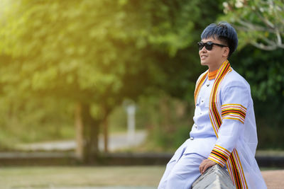 Young man against trees in park