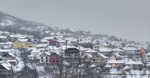 Houses in city against sky during winter