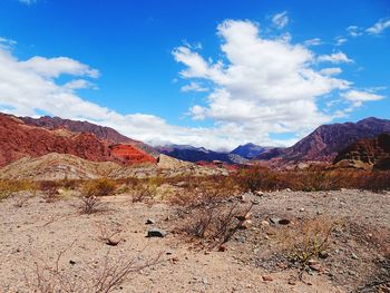 Scenic view of landscape and mountains against blue sky