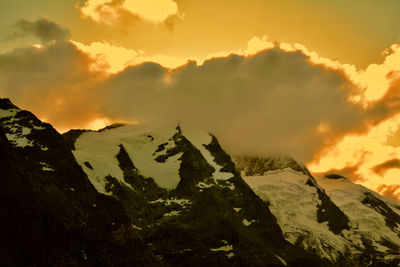 Scenic view of snowcapped mountains against sky during sunset