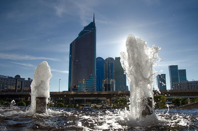 Fountain in city against sky