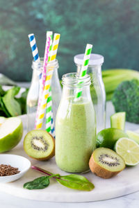 A healthy green smoothie in glass bottles, ready for drinking.