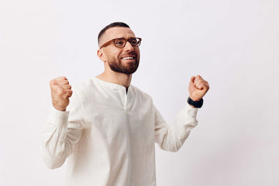 Portrait of young man standing against white background