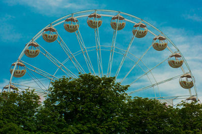 Low angle view of ferris wheel against blue sky