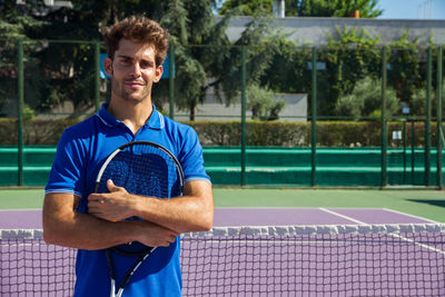 Portrait of tennis player standing in court