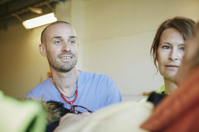 Male doctor and female paramedic looking at patient in hospital