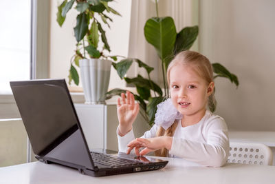 The girl learns , communicates, talks, through a computer / laptop