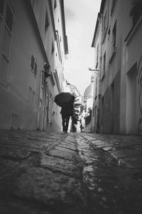 Man walking on alley in city