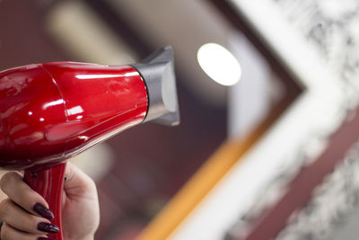 Cropped hand of woman holding hair dryer