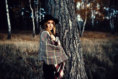 Woman standing on field in forest