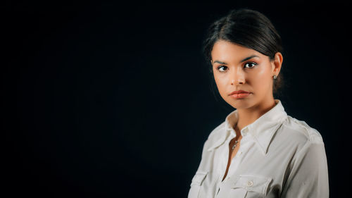 Portrait of a beautiful young woman over black background